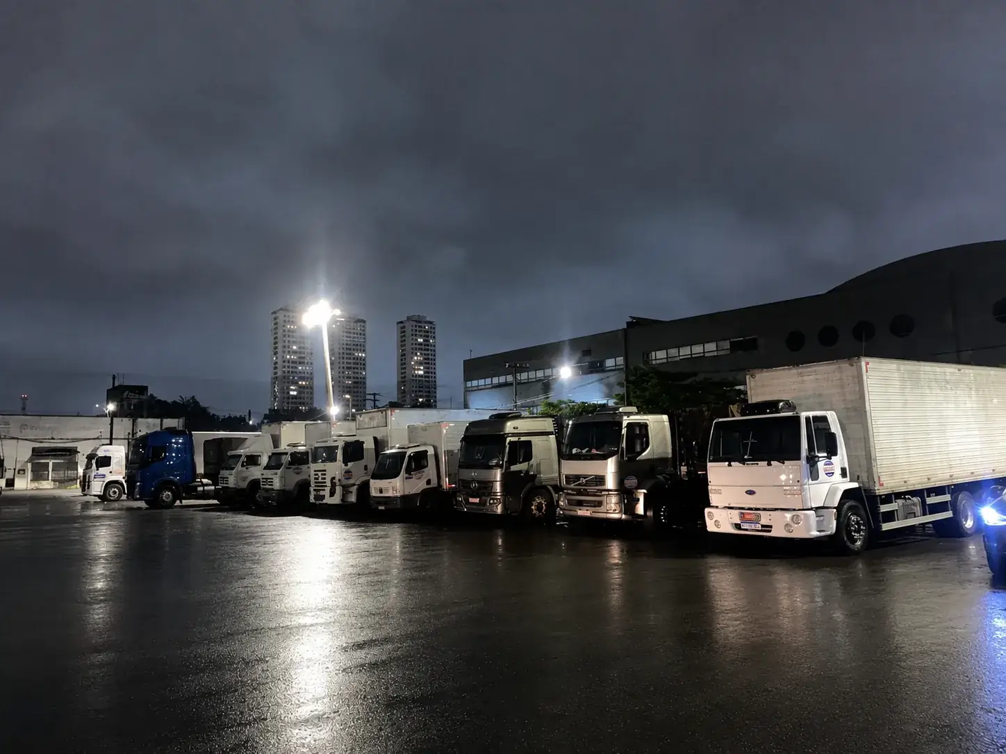 Frota de caminhões Gallindo alinhada no pátio antes da saída para entregas